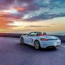 Porsche Boxster convertible on the coast road at sunset