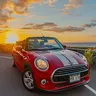 Red Mini Cooper convertible at sunset in Kona